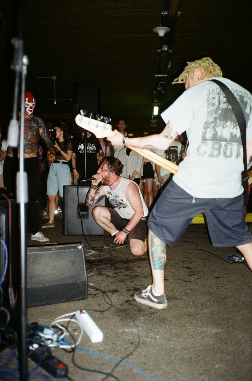Dynamic live performance of a punk band in Moscow featuring bassist and singer passionately engaging the crowd.